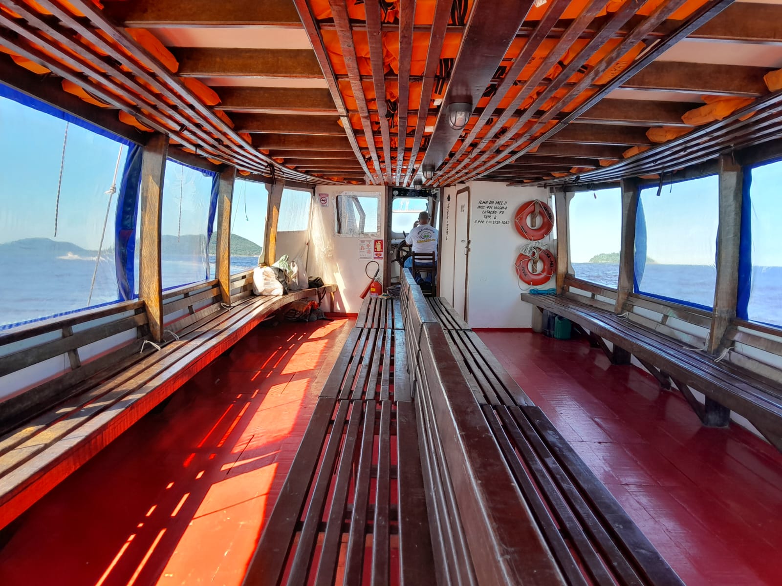 Área interna da embarcação com assentos e coletes salva-vidas